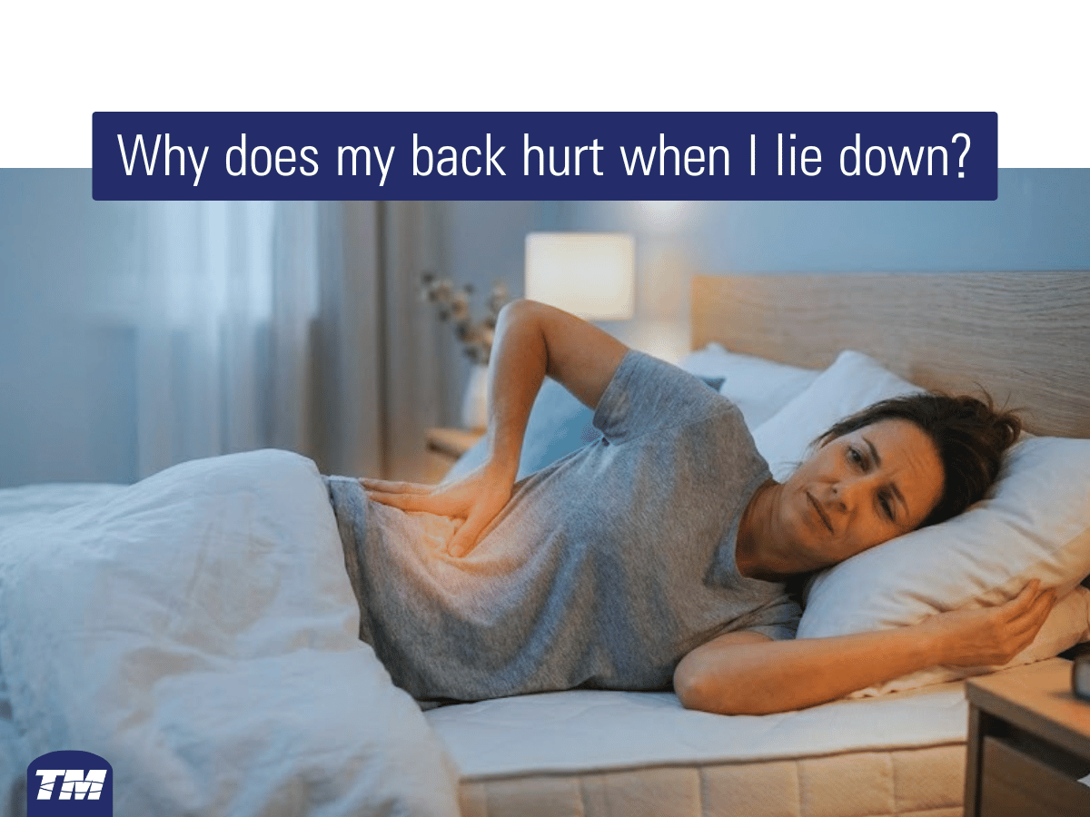 Woman experiencing lower back pain while lying in bed at night